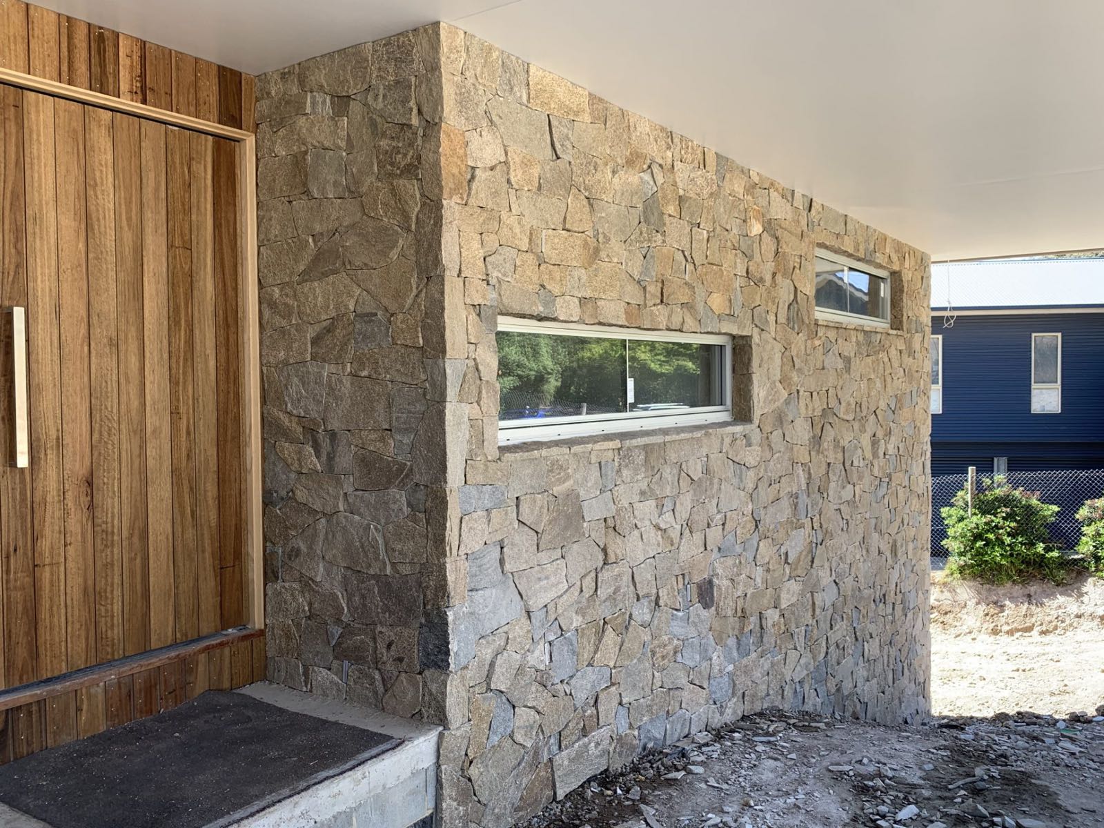 Random-rubble stone facade with timber detailing, built by Creative Stone Masonry